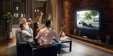 Group watching a race on TV, cheering excitedly.
